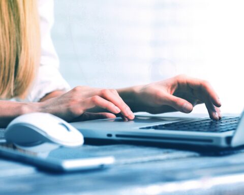 a woman is typing on a laptop computer
