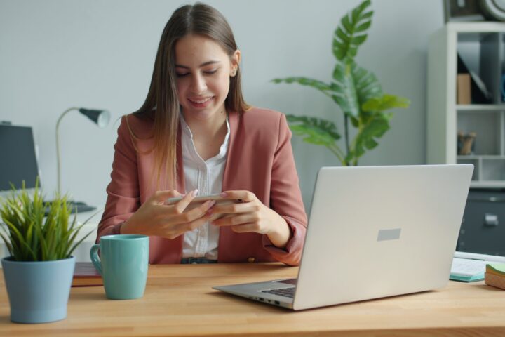 Young woman working at a desk with laptop and laptop