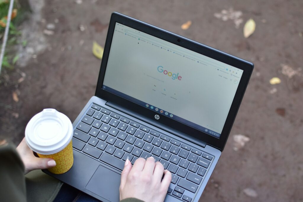 a person using a laptop computer with a cup of coffee