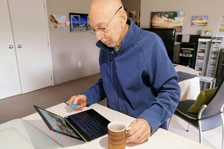 man in blue sweater using macbook pro