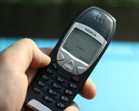 A hand holds a vintage nokia phone.