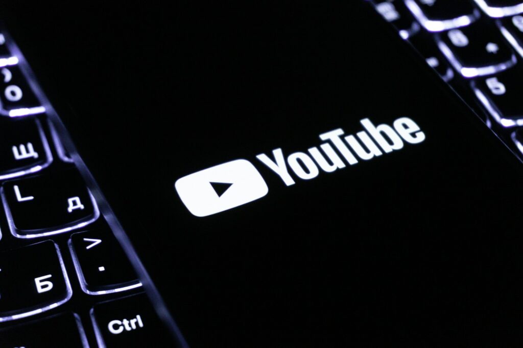 The youtube logo on a smartphone is visible.