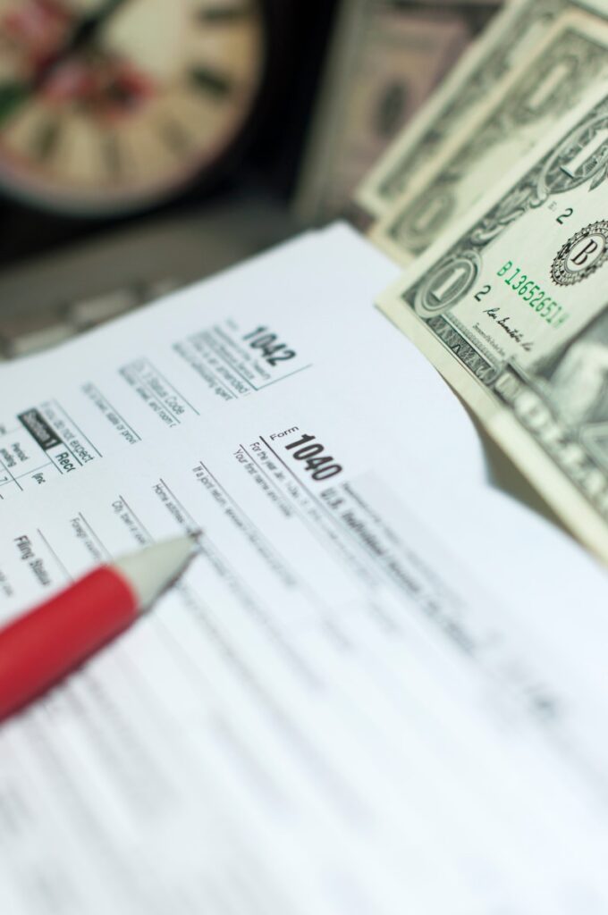 Tax forms with dollars and pencil
