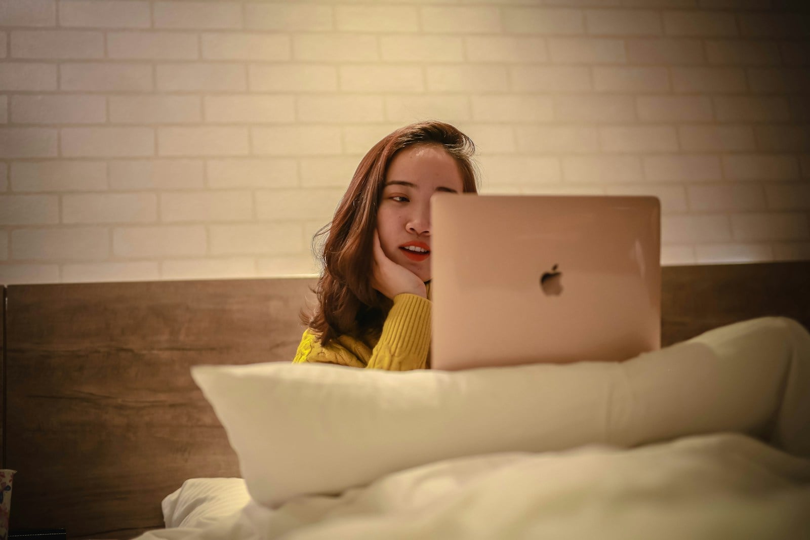 woman in yellow shirt using silver macbook