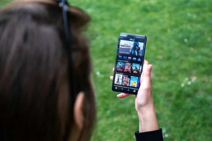 woman holding black android smartphone