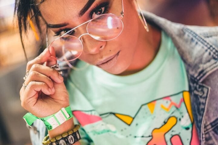selective focus photography of woman holding eyeglasses