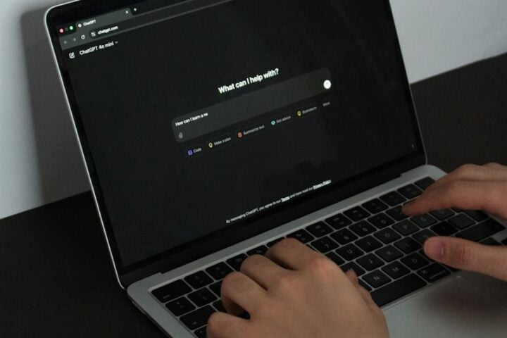 A person typing on a laptop on a table