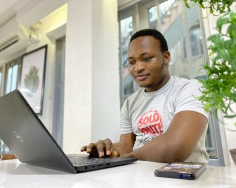 man in white and red crew neck t-shirt using laptop computer