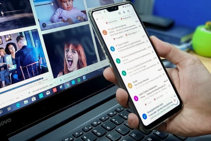 person using smartphone and laptop computer