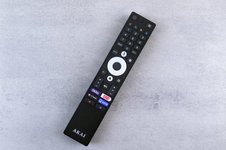 Black akai remote control on a grey surface
