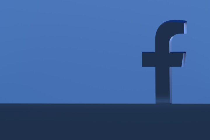 a person standing in front of a facebook logo