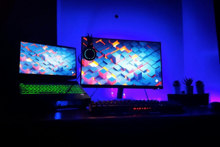 two computer monitors sitting on top of a desk
