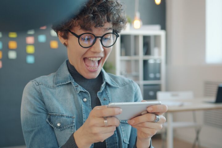 Excited woman playing a game on her phone
